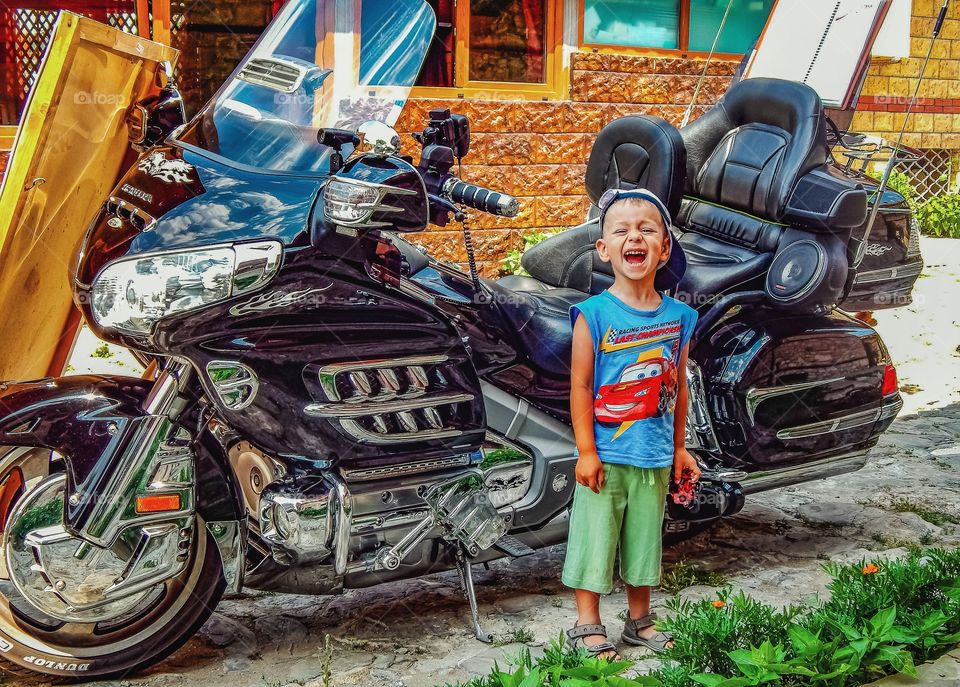 a child stands near a motorcycle