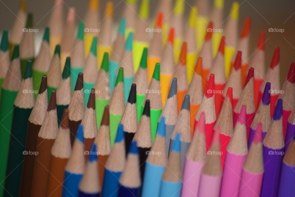 Abundance of colored pencils arranged in a row