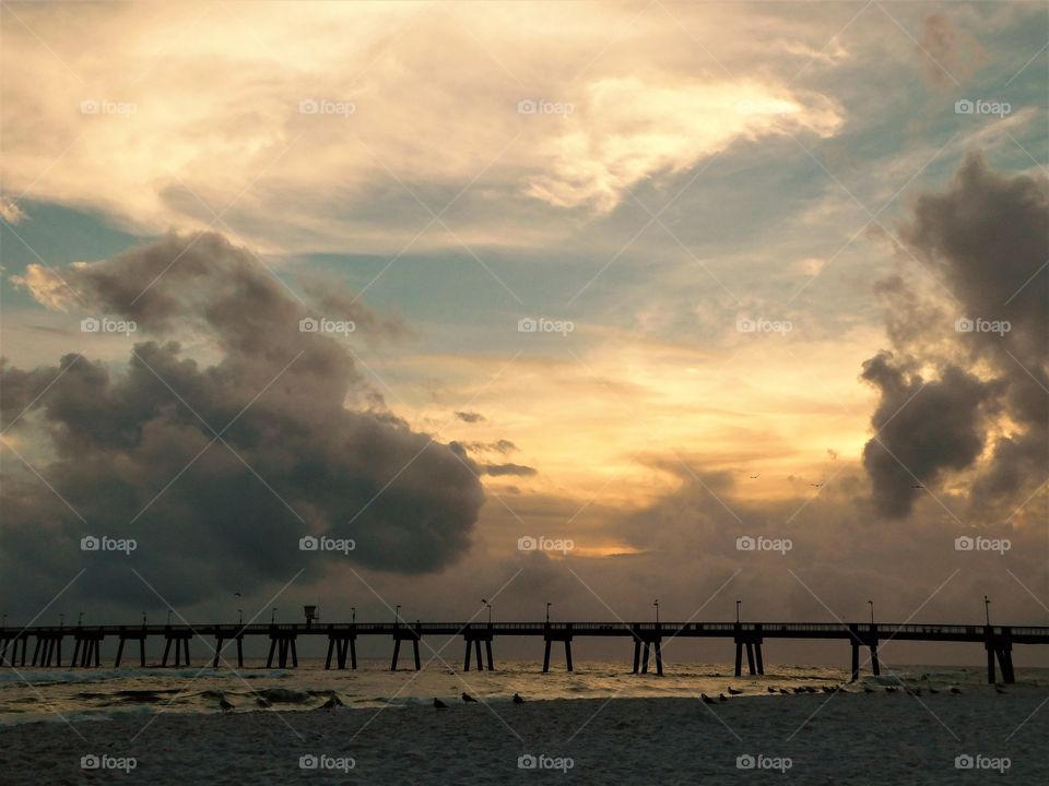 Silhouette of pier against dramatic sky