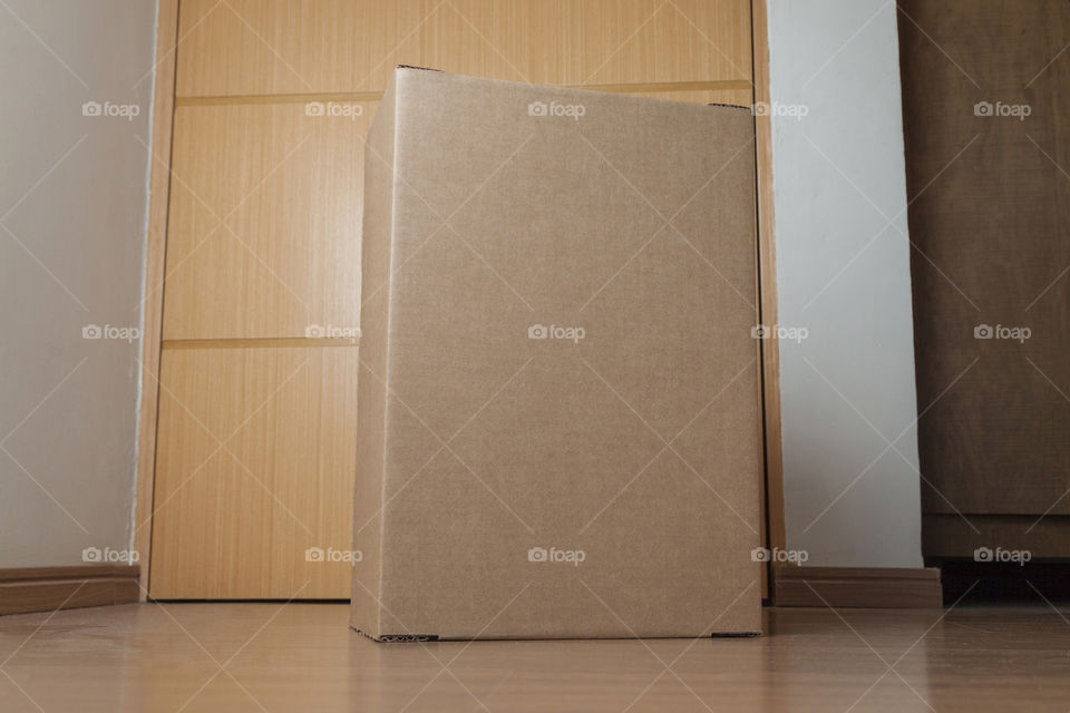 Cardboard box with order placed on the floor in an empty room with a neutral background. delivery concept. economy concept. business concept. shopping concept. copy space. Nobody