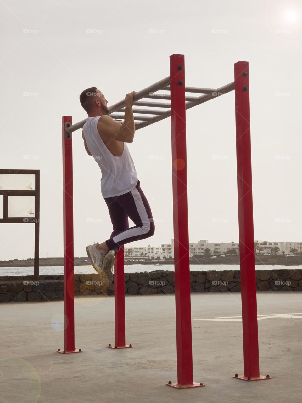 chico joven entrenando en la calle en exteriores, usando bandas elásticas y realizando ejercicios variados