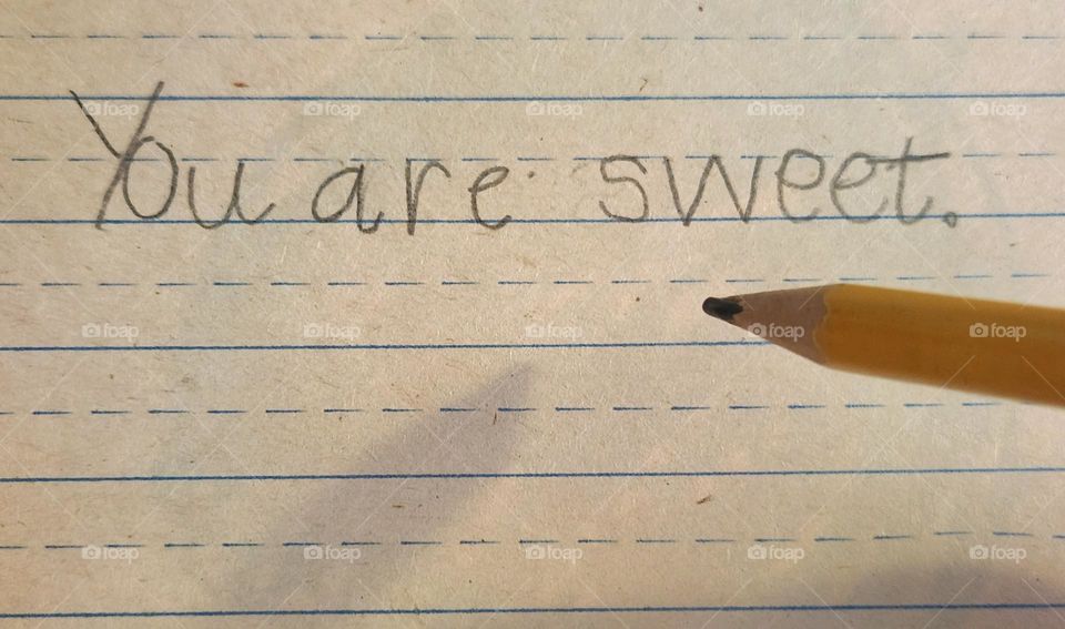 kind message written by a child in pencil on lined paper to a friend or family member in school