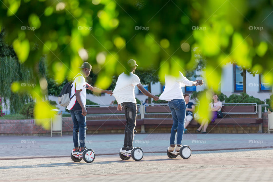 Friends having fun in summer riding gyro scooters
