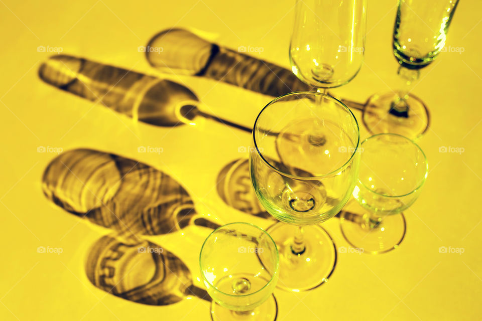 Wine glasses with shadow on yellow background 