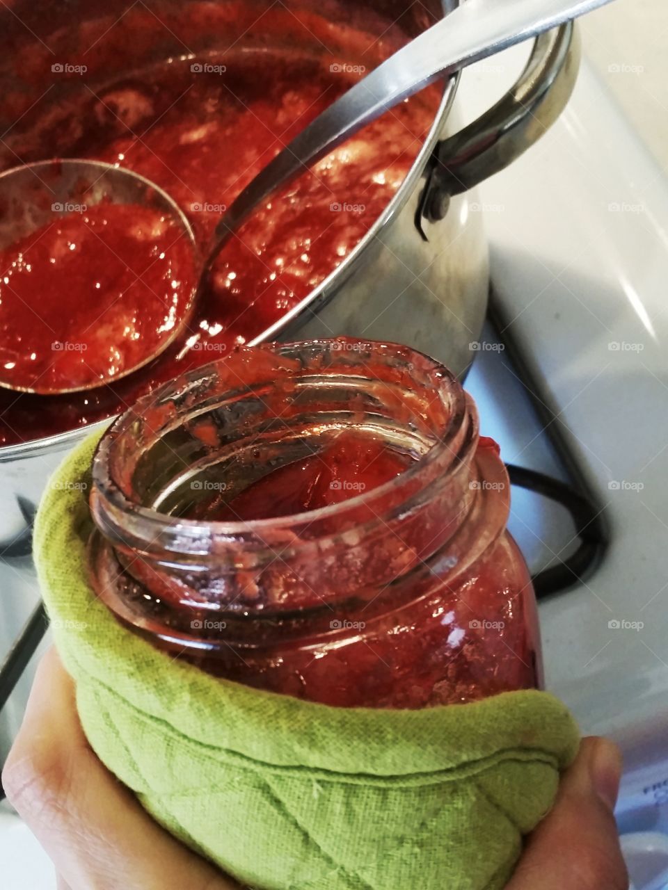 Cropped hand image pouring pickle in jar