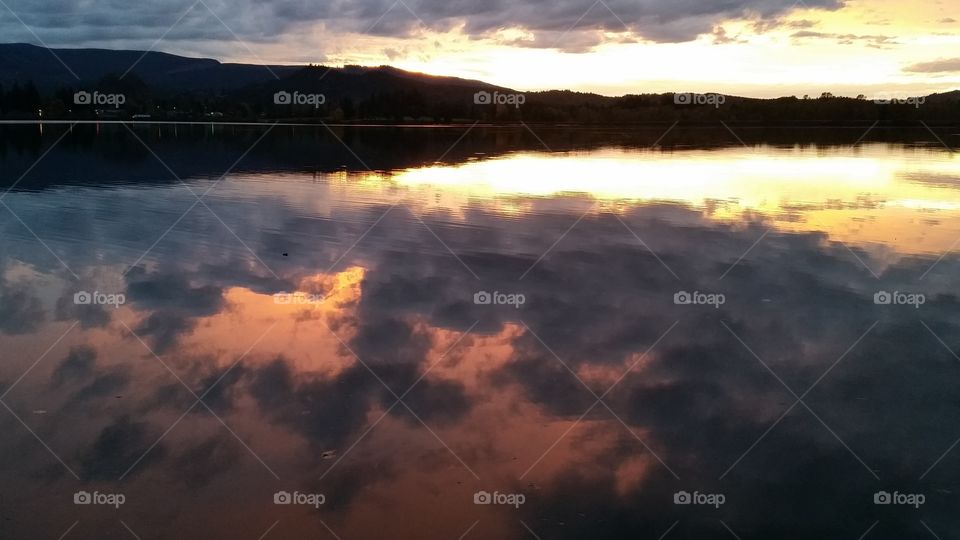 Sunset with dramatic clouds reflected in lake