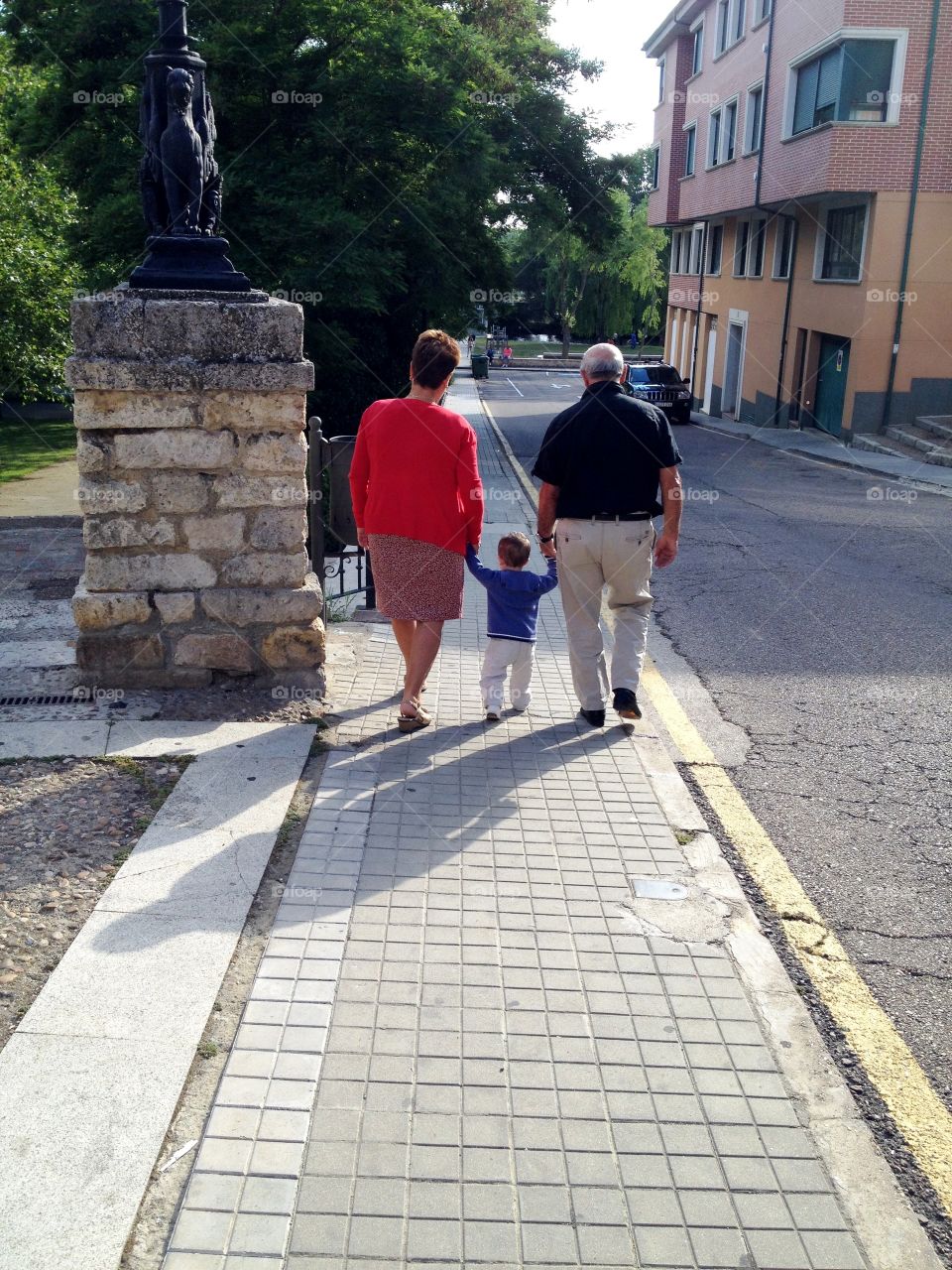 the grandparents walking slowly with the grandson by the hand