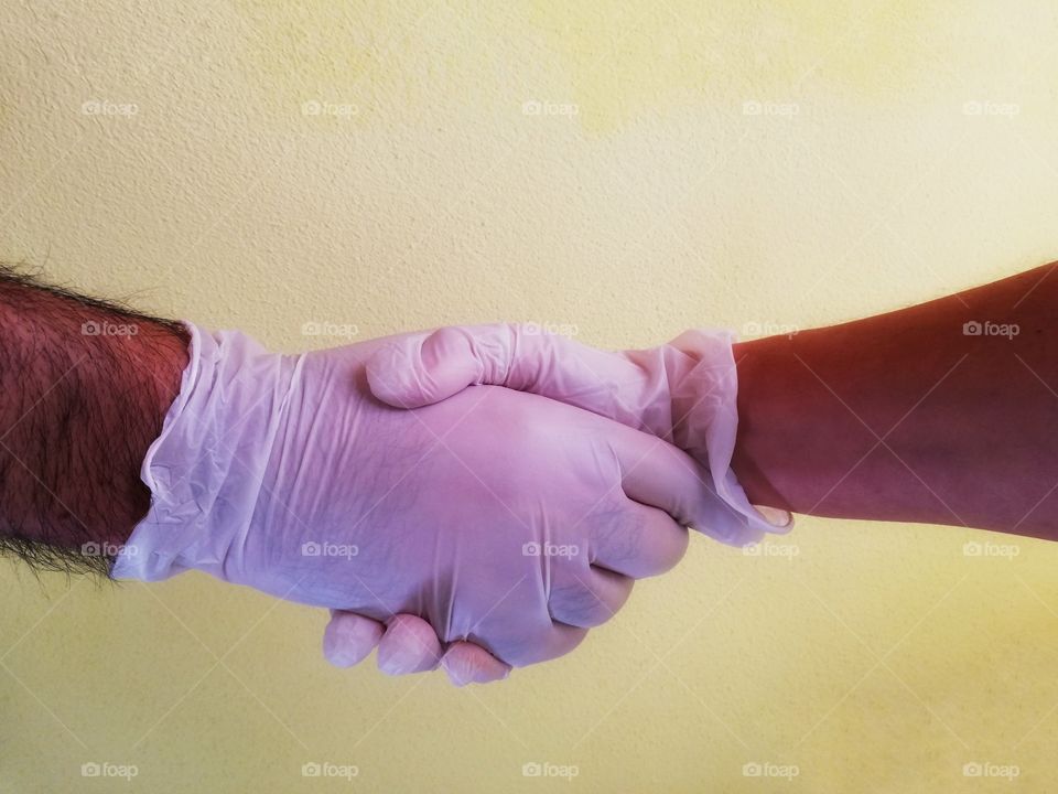 Handshake with latex gloves at the time of covid-19