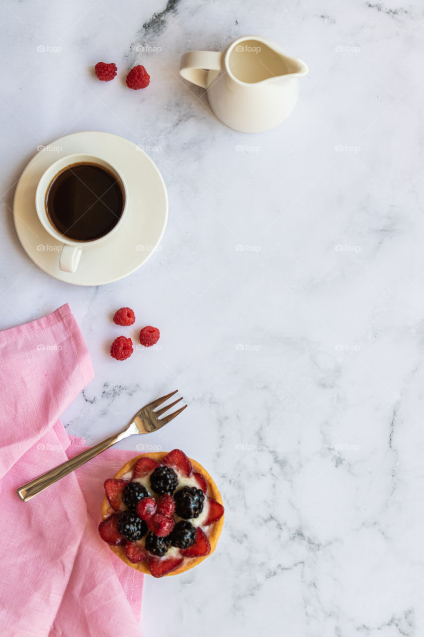 Top view to still life made by cup with coffee and some dessert.