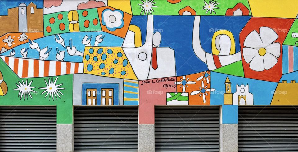 Rectangular shuttered doors, surrounded by colourful, vibrant street art