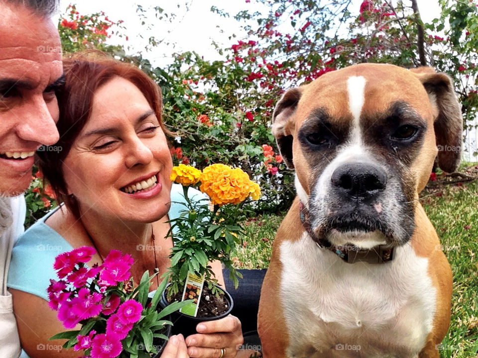 Couple with dog and flowers in backyard