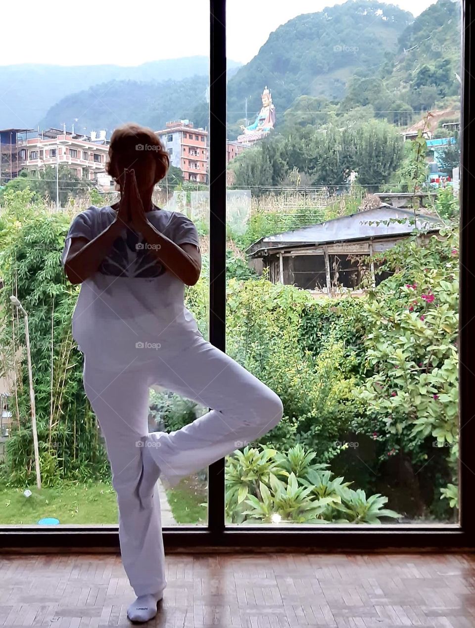 Woman staying in yoga pose near the window in Nepal