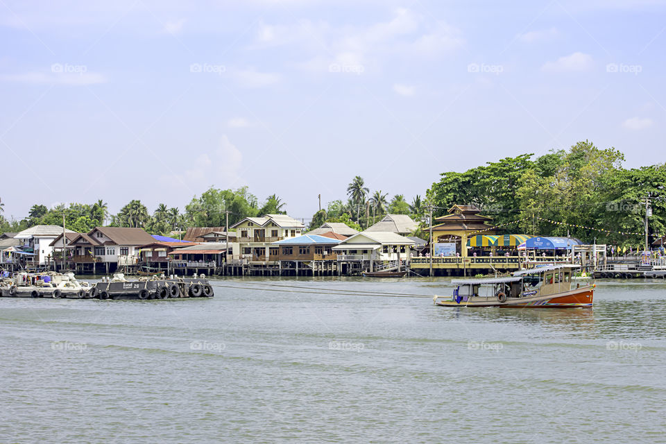 A boat load of sand in Chao Phraya River Background cityscape and sky at Pak kret in Nonthaburi , Thailand. April 16, 2019