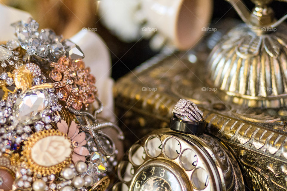 Wedding rings on top of a vintage telephone with a broach bouquet