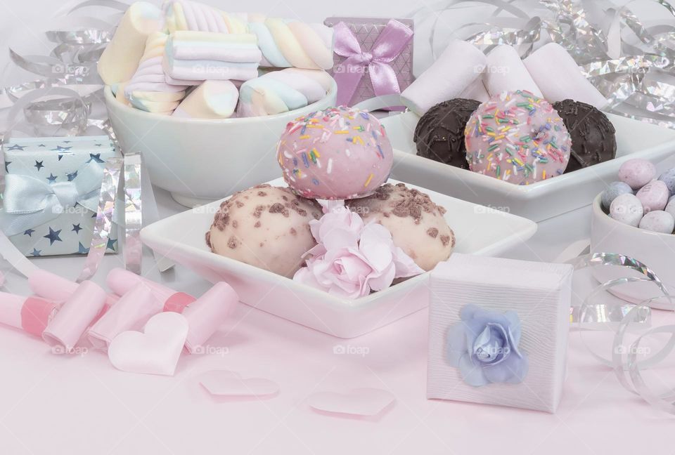 Tea party sweets & treats in pastel colours, with streamers, gift boxes and party blowers