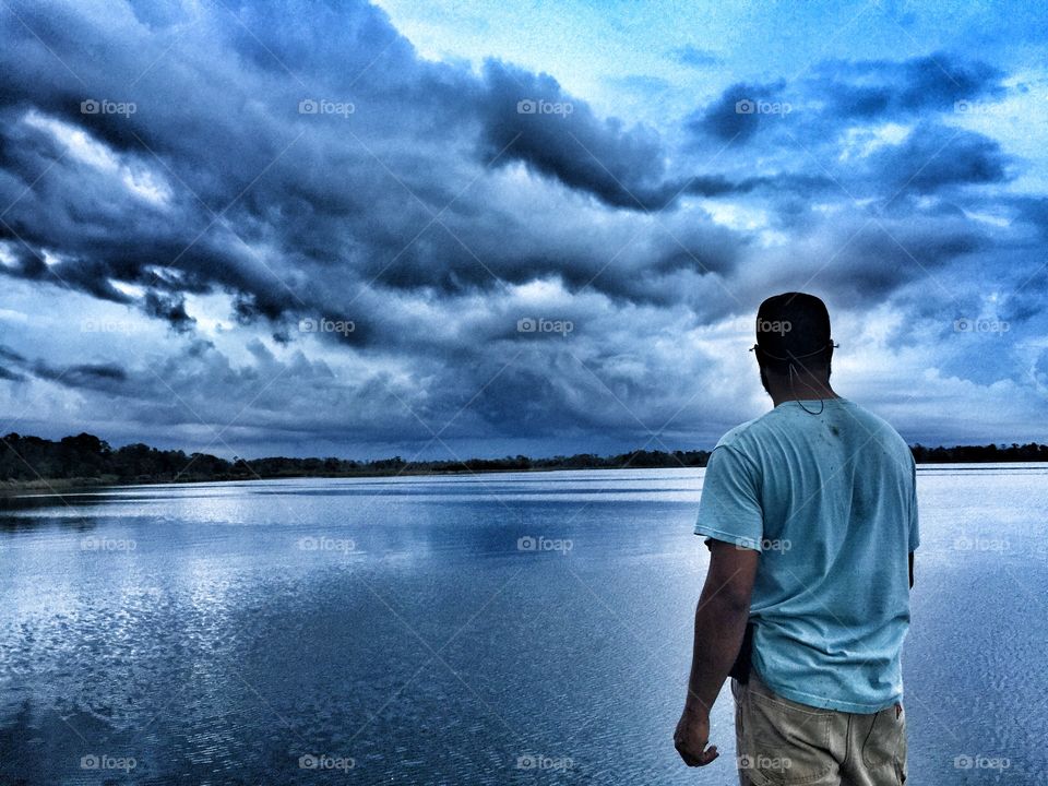 Rear view of a man looking at lake