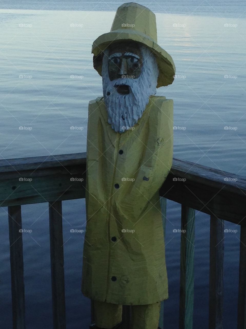 Wooden figure of man wearing raincoat