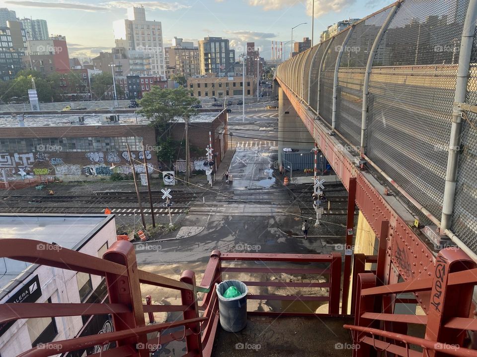 This is a view down the steps of the “Pulaski Bridge” onto the train tracks and the pedestrian crossing in “Long Island City”, Queens. 2023. Hypnotic Productions