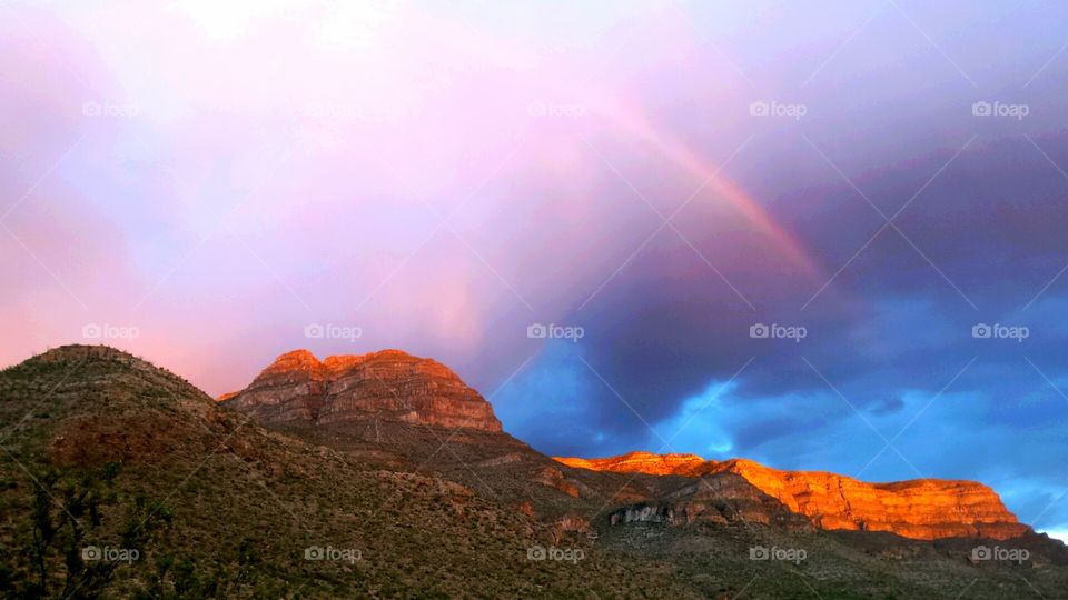 Sun Setting on Mountains & Rainbow
