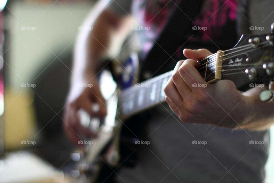 musician playing guitar view of the fretboard