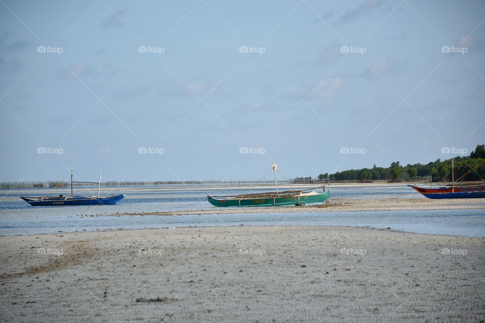 white sand beach and boats