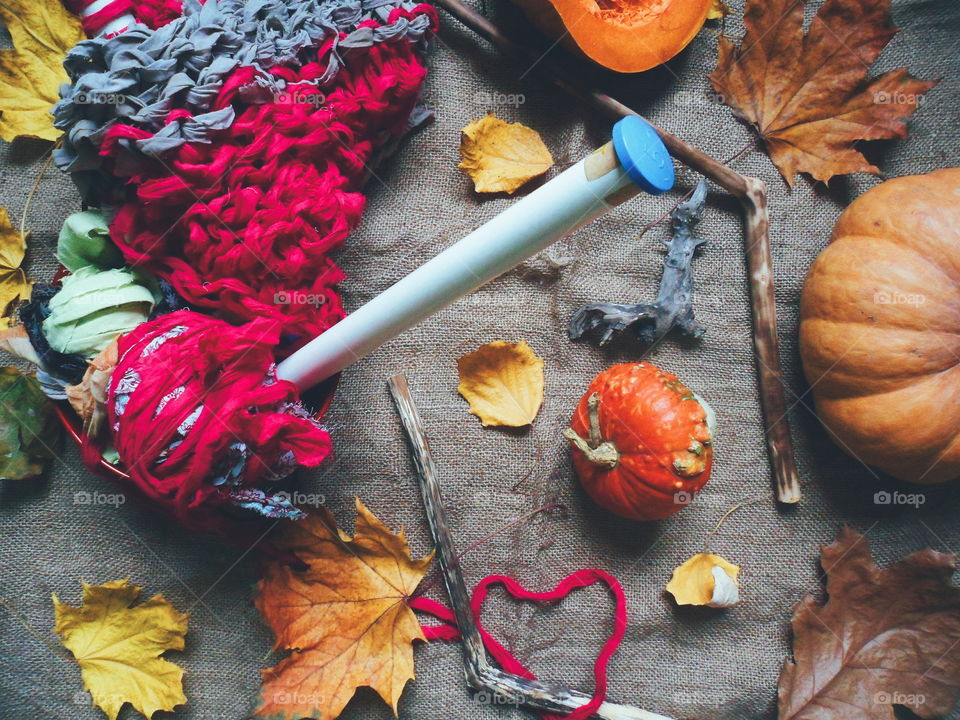 pumpkin, autumn leaves and knitting on the table