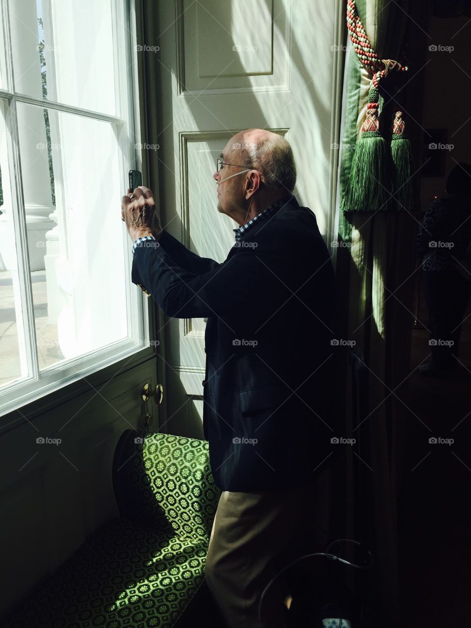 Senior man taking photograph with mobile phone