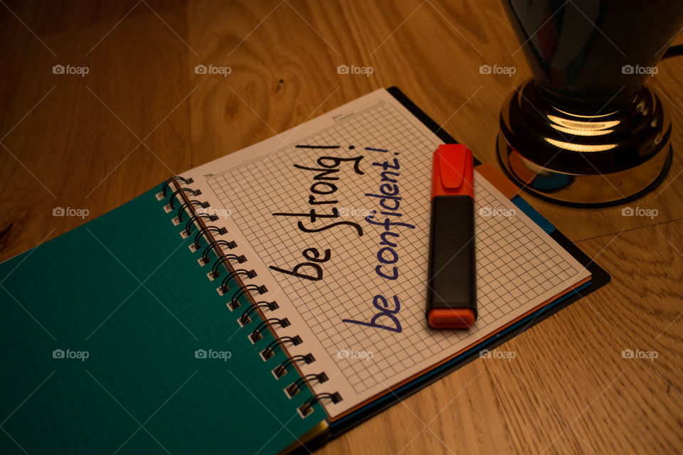 Motivational letter in a notebook on the desktop under the light of a lamp