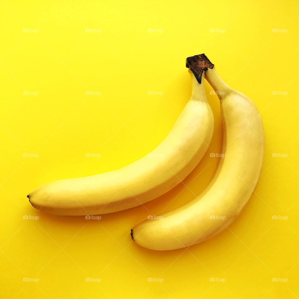 Two bananas on yellow background