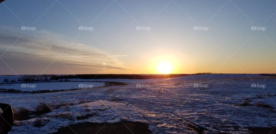 sunrise over the snow covered flat land