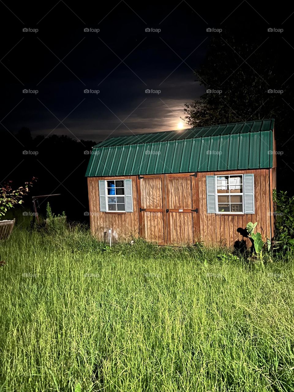 A Alabama country view of a little barn with a beautiful scenery of the moon.