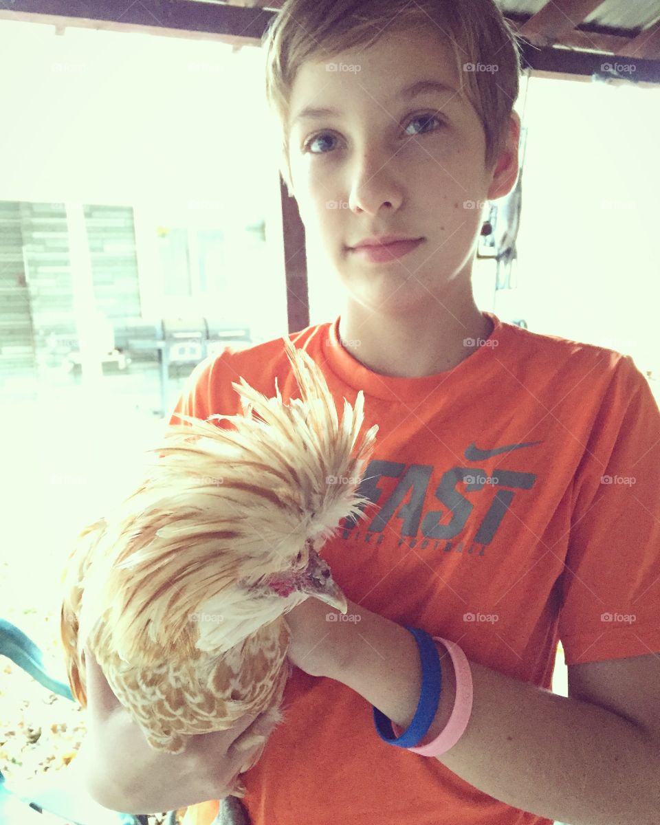 A boy and his chicken. 