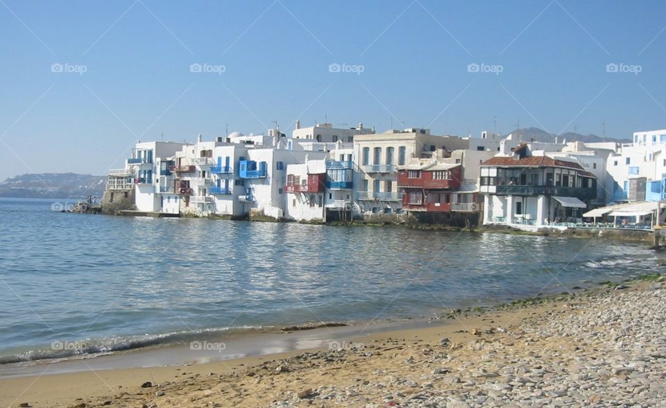 Mykonos shoreline of wonderful Greek architecture towering over the ocean, a beautiful location for a sunset