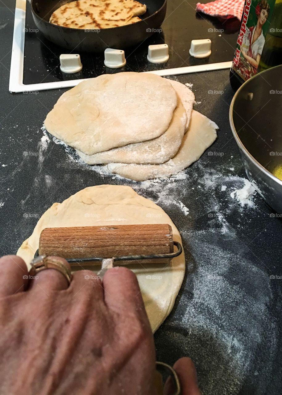 Woman rolling bread dough for pita