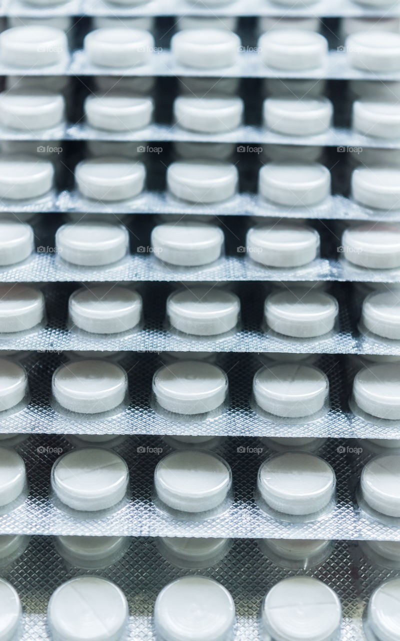 Heap of Capsules packed in blisters, round patterned shaped medicine tablet or antibiotic pills. Medical Pharmacy theme. Close up with copy space.