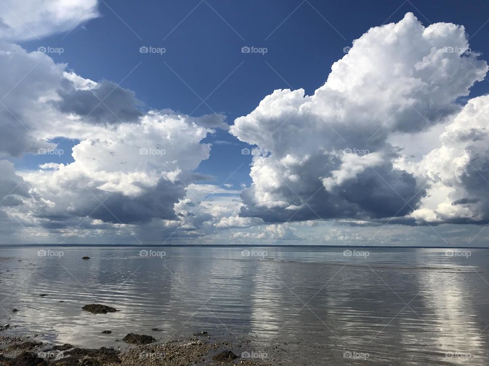 Huge puffy clouds over water