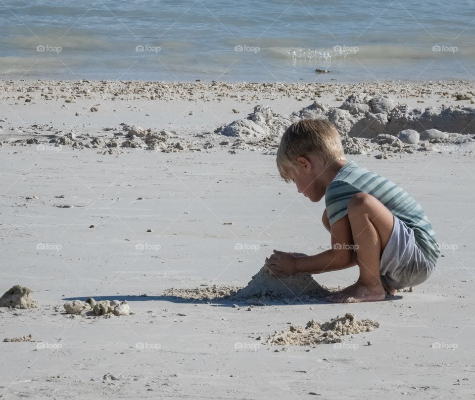 A boy try to build his sand castle on the beautiful beach