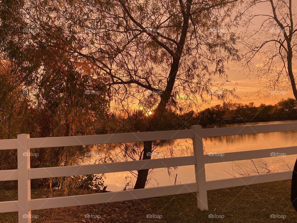 Evening Sunset covered with High Clouds Reflections with Willows trees  along the lake bed. 