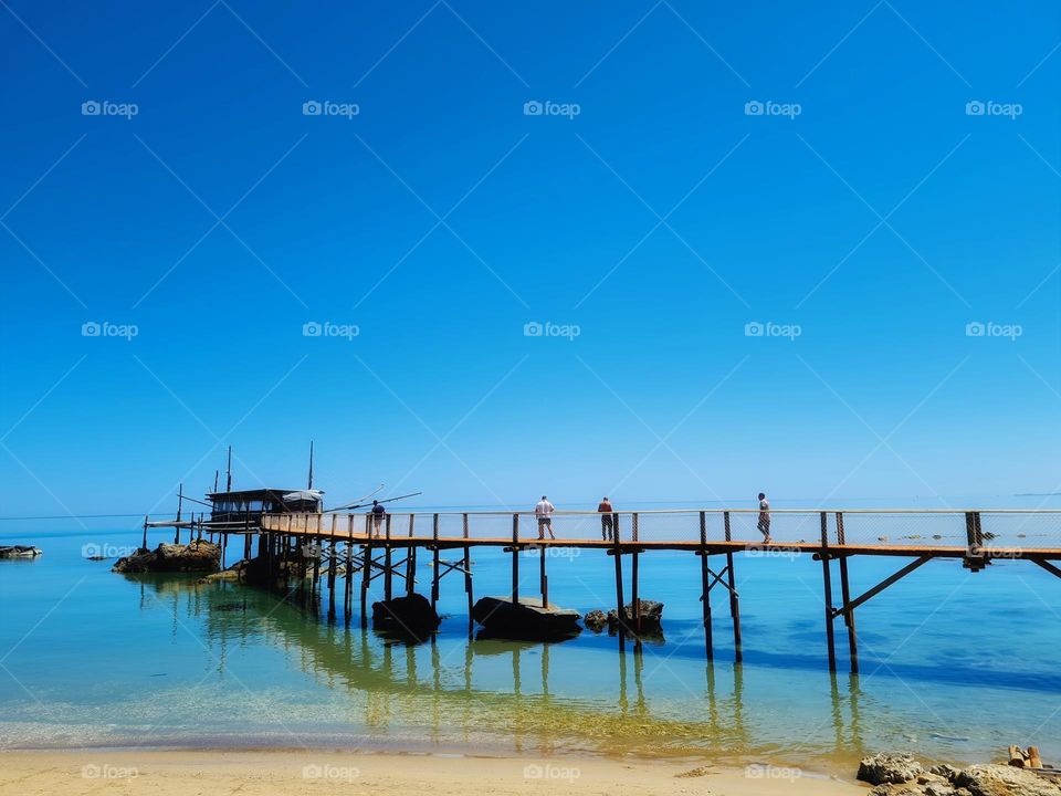 people walk on the wooden walkway of an ancient overflow