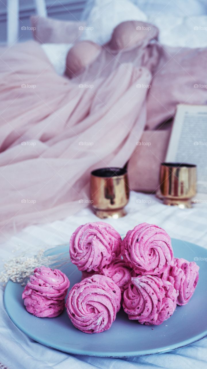 pink marshmallow on bed with dress and books