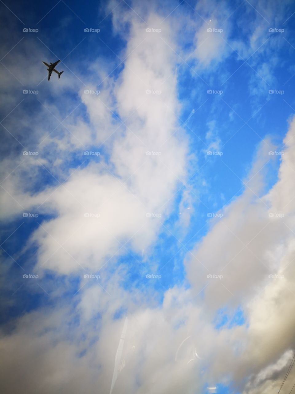 Airplane Flying Through Cloudy Blue Sky