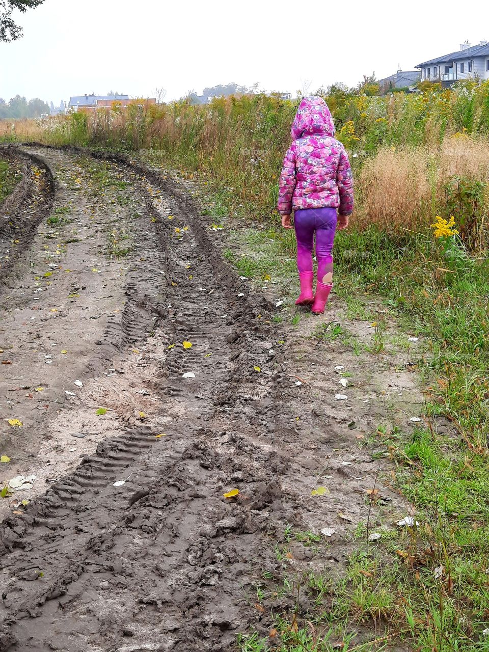 kid walking on a rainy day in autumn