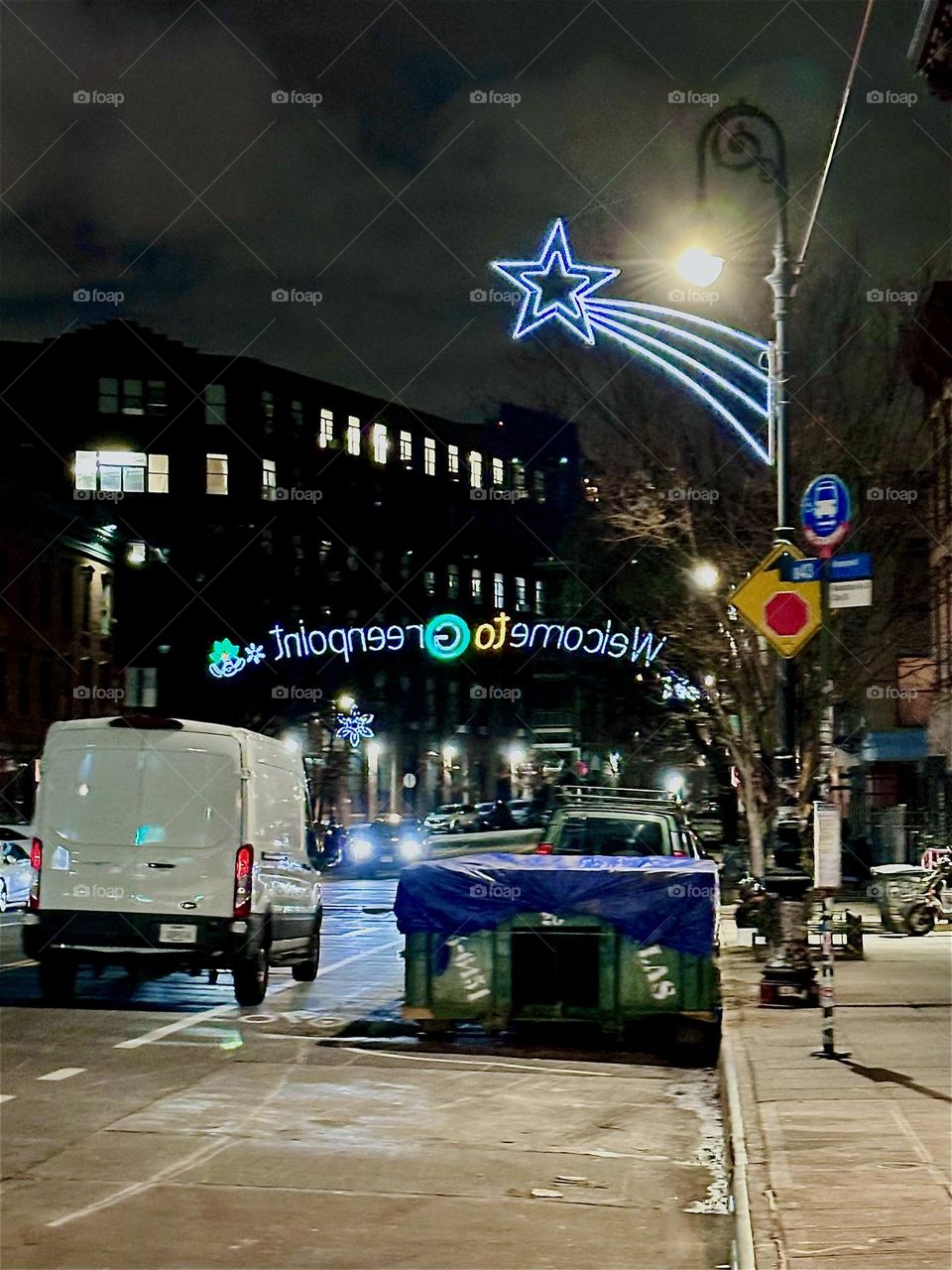 This is “Manhattan Avenue” in “Greenpoint”, Brooklyn with an inviting “Welcome to Greenpoint” fluorescent sign spanning across it along with a neon comet star that accompanies it. 2023. Hypnotic Productions