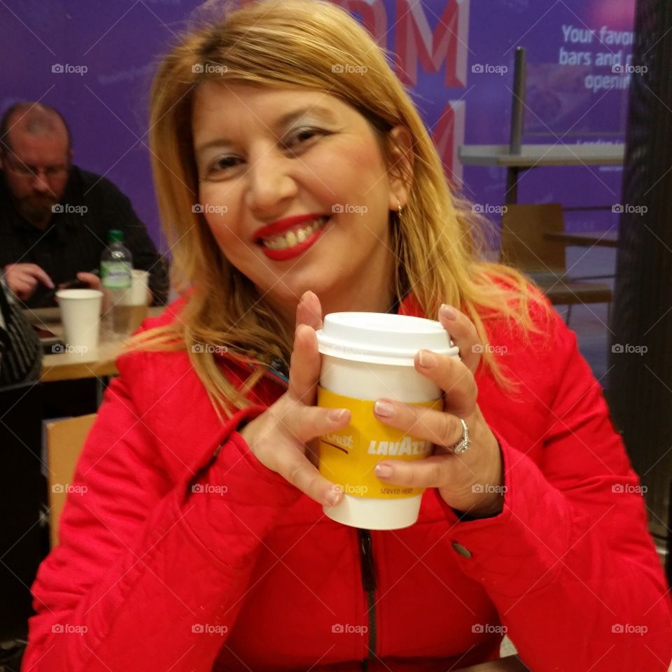 Happy woman sitting in café with glass of coffee
