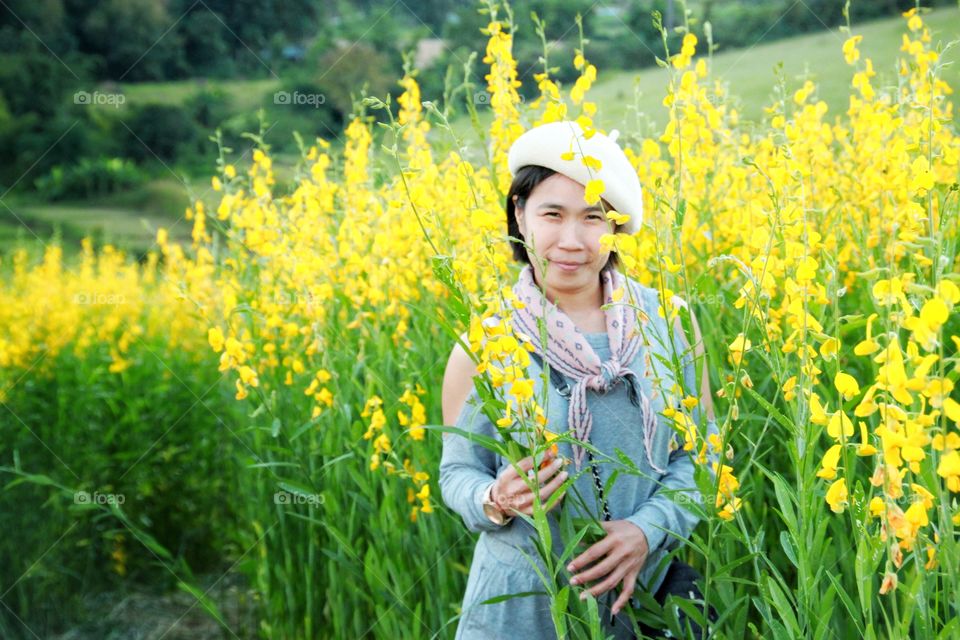 Woman are happily standing among the blooming flowers and beautiful nature.