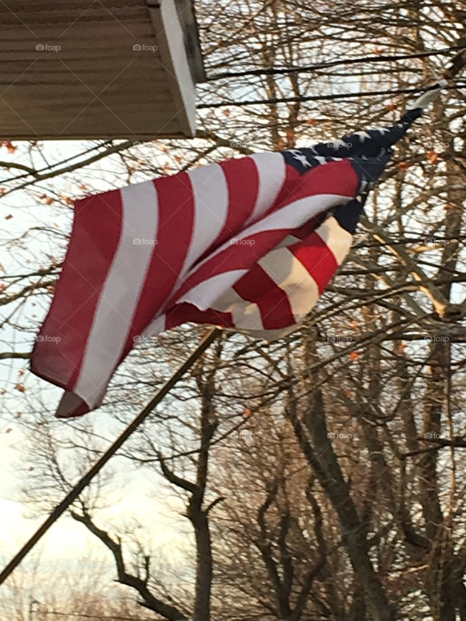 American flag flying in the wind at my house. Good ole red white and blue 