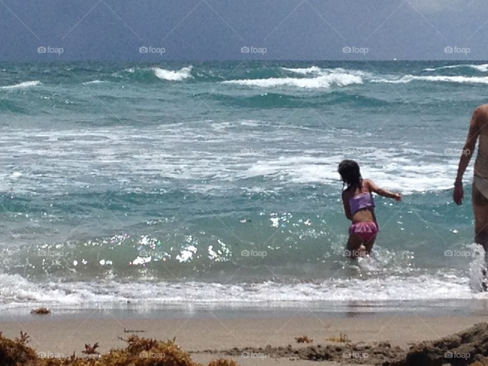 Childs soul. Little girl playing in ocean