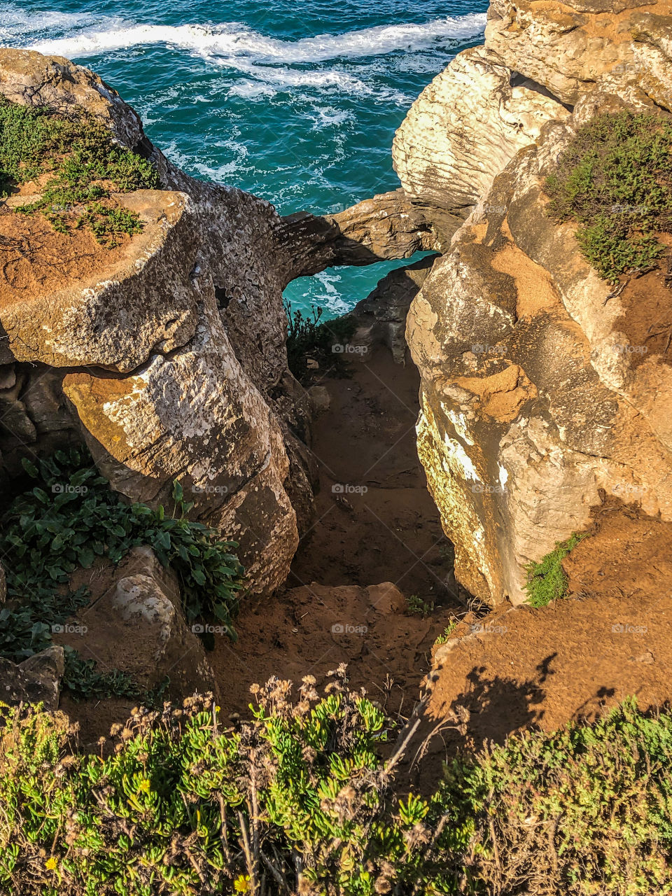 The view from up above down through a hole in the cliffs to the sea