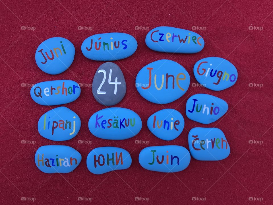 24 June, calendar date in many languages with colored stones and red background 