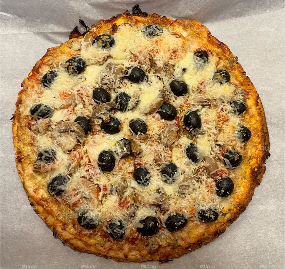 Homemade pizza with lots of black olives.